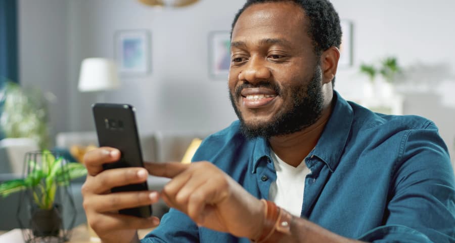 Man in his home navigating an app on his phone